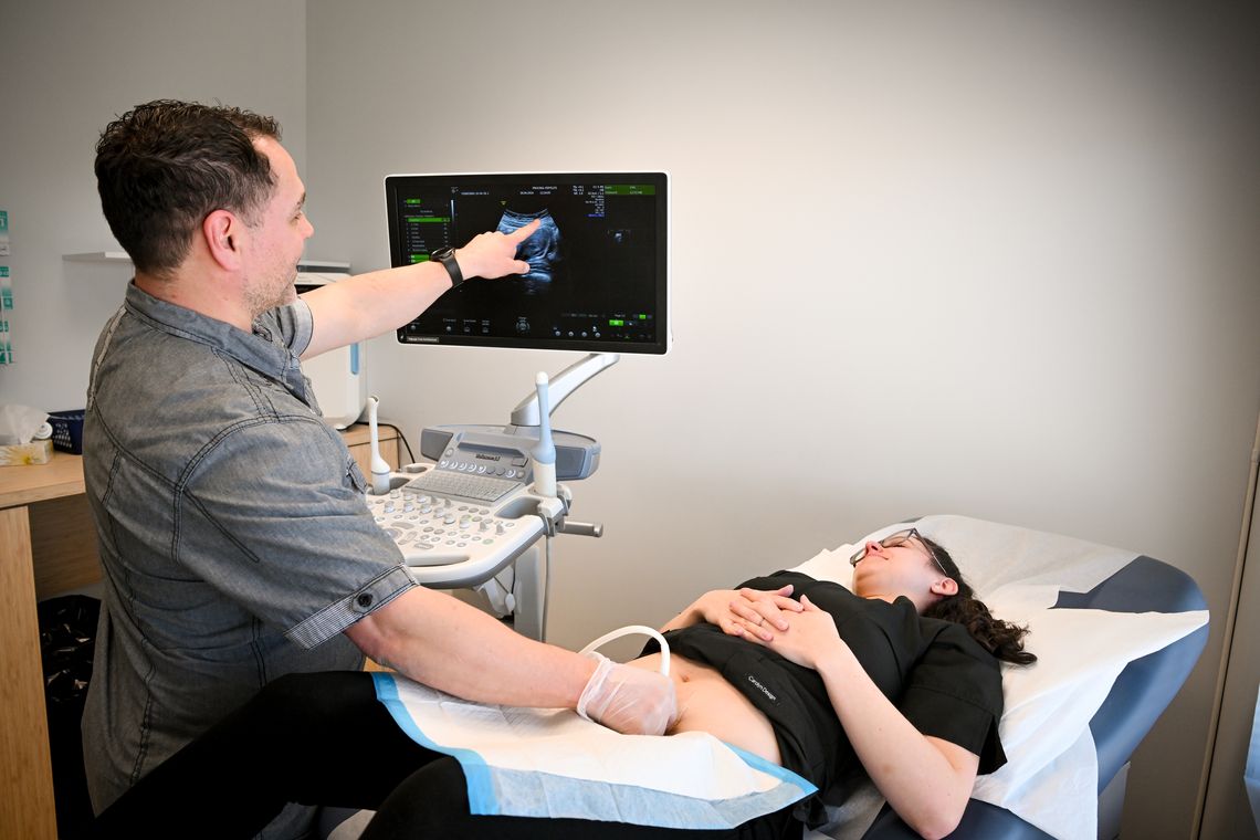 doctor examining woman on bed